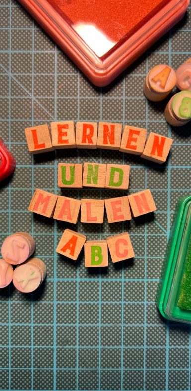 Bunte Stempel auf Schneidematte schreiben „Lernen und Malen ABC“ – verspielte Einladung zum Buchstabenlernen & kreativen Ausdruck