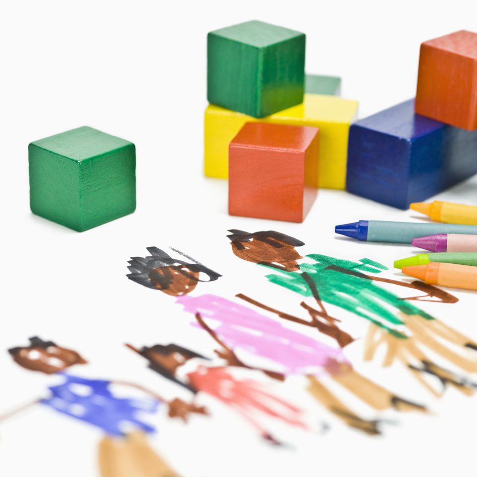 Kinderzeichnung mit bunten Wachsmalstiften und Holzbausteinen – Symbol für Kreativität und Bildung.
